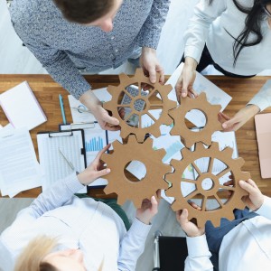 Employees in office connect gears in place. Business team building concept